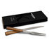 A stainless steel carving fork with wooden handles, packaged in a black box featuring a logo.