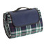 A rolled picnic rug with a checkered pattern in green, white, red, and navy, featuring a handle for portability.