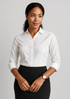 A white women's button-up shirt with 3/4 sleeves, paired with a black skirt and a watch. Features branding. A white women's button-up shirt with 3/4 sleeves, paired with a black skirt and a watch. Features branding.