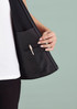 A black women's vest with a zip front and an inner pocket, showcasing the interior design details.