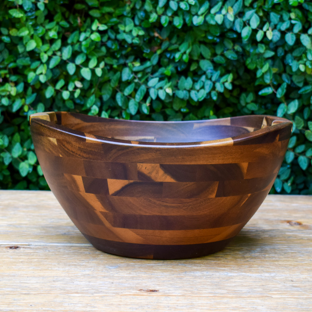 Enhance your table setting with this oversized acacia salad bowl. Featuring two contoured serving tools that sit flush inside the bowl it is sure to be a conversation starter.