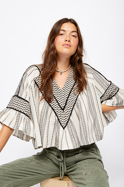 A light and easy top perfect for any party! The Free People Runnin On A Dream Top features striped embroidery throughout , an exaggerated ruffle sleeve with a boxy cropped silhouette. 
