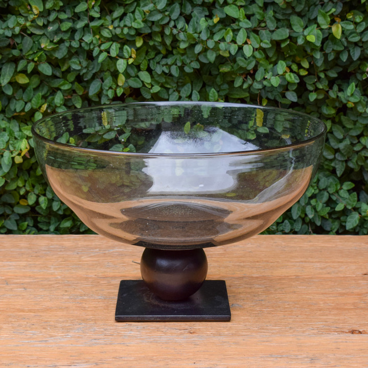 Jan Barboglio's Evolucion Glass Bowl is as much a piece of art as it is a functional serving piece. The mouth blow glass bowl sits atop an iron stand with ballin. The iron finish embraces the iconic Jan Barboglio feel of warm, rustic, and refined. Perfect as a centerpiece, fruit bowl, or even serving bowl. 