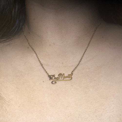 A woman wearing a gold Dog Mom necklace