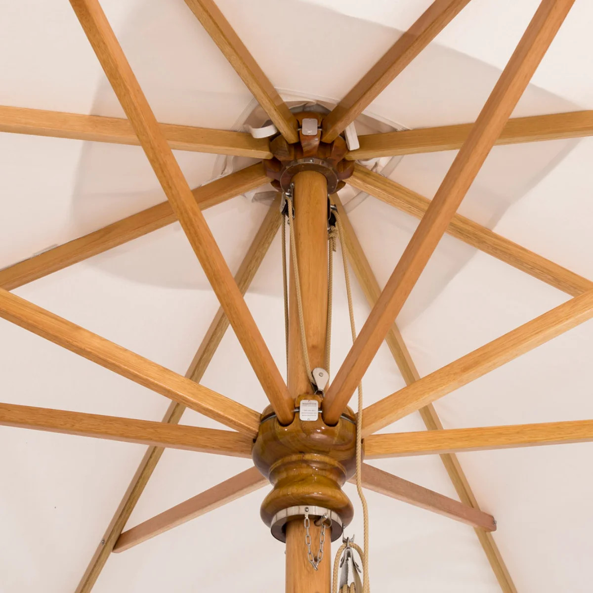 Underside of a wooden patio umbrella canopy with white fabric