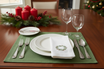 table setting with green placemat and white napkins with wreath design