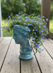 Grecian Head Planter planted with Blue Daze in the Sea Glass finish