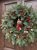 Bright red stocking ornament on front door wreath
