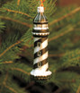 black and white blown glass lighthouse ornament hanging on tree