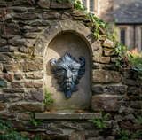Bronze Greenman in small niche of stone wall