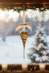 Cone shaped Pyrex glass ornament with red and green swirls in window