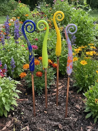 Grouping of Fiddlehead Glass Finials in garden