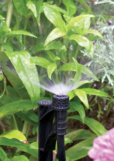 Rivulis Tornado Mister emitting a fine upright mist onto green leaves