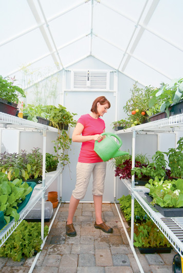 Solexx Garden Master Greenhouse interior with a person watering plants.