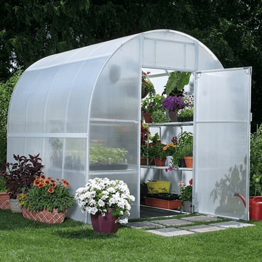 Solexx Oasis Greenhouse front view, filled with vibrant potted plants and hanging flowers.