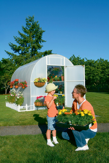 Family gardening together inside a Solexx Oasis Greenhouse.