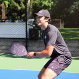 ProXR "The Story" 14 Pickleball Paddle has a forehand fiberglass face and backhand carbon fiber face. Black background with large ProXR logos on each side, white outline and details on the fiberglass side, with yellow outline on the backhand side.