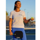 Pickleball player holding a neon ball in one hand and the CRBN-2 Pickleball Paddle in the other hand