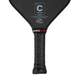 Close up view of the Eastern Slim style handle of the ProXR Raw Carbon 14 Pickleball Paddle. Featuring a black performance tac cushion grip with branded band at the top