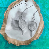View of the Silver Born to Rally Pickleball Paddle CZ Dangle Earrings displayed in a shell.