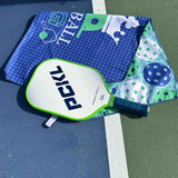View of the Born to Rally Pickleball King Double-Sided Microfiber Towel on court with paddle.