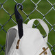 Close up view of Franklin Sling Bag, white with gold trim and built in fence hook, hanging on a fence.