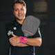 Athlete posing with Evoke Premier Pro Raw Carbon Pickleball paddle.