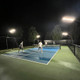 Dominator ALTA Portable Outdoor Overhead Lights illuminating a pickleball court at night