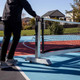 View of the Dominator Pro Max Portable Pickleball Net being placed on a pickleball court