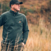 Man in field wearing Jack Pyke pheasant motif fleece top with wax baseball cap