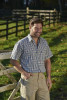 Man in open field wearing Champion Doncaster green check shirt – lightweight and breathable