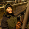 Female farmer wearing Stoney Creek Women’s Tempest Jacket while milking, a reliable waterproof kit for dairy work