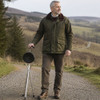 Person carrying the Trio Maxi Folding Seat Stick folded as a walking stick on a countryside path.