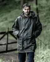 Dog walker wearing Hoggs of Fife Woodsman wax jacket in the rain for reliable waterproof protection