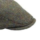 Green Harris Tweed flat cap in a herringbone pattern
