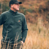 Man in field wearing Jack Pyke pheasant motif fleece top with wax baseball cap
