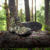 Camouflage waterproof walking boot by Northwest Territory in forest on a log showing rugged outsole grip