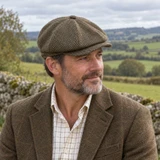 Man wearing Harris Tweed Newsboy cap with a green brown tweed jacket