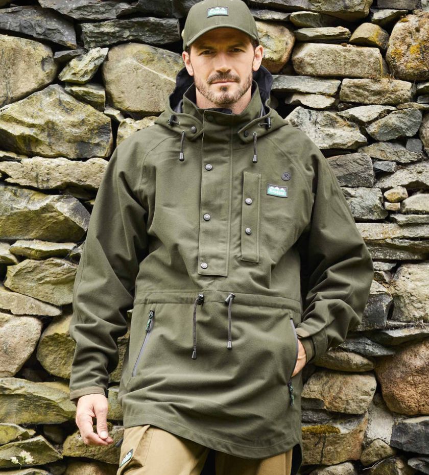 Farming waterproofs. Farmer mending stone wall in waterproof smock