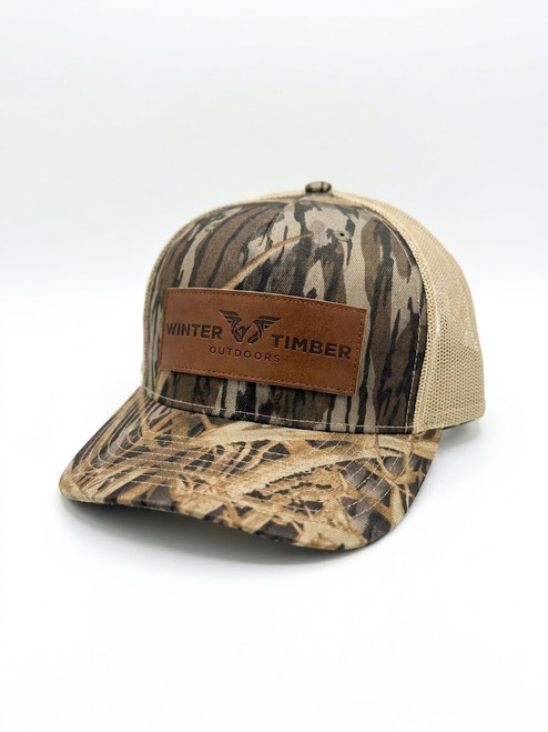 Gear up with the Winter Timber Outdoors Leather Patch Hat. Authentic Mossy Oak Shadow Grass camo built for waterfowl hunting and casual outdoor wear.