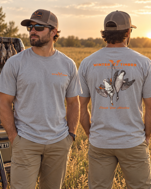Shop the Winter Timber Outdoors Deuce Goose Tee. Premium light heather grey waterfowl hunting shirt featuring a custom goose strap back graphic.