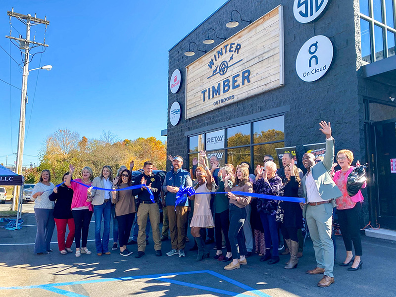 The Winter Timber store team standing in front of the recently remodeled store for a grand opening ribbon cutting.