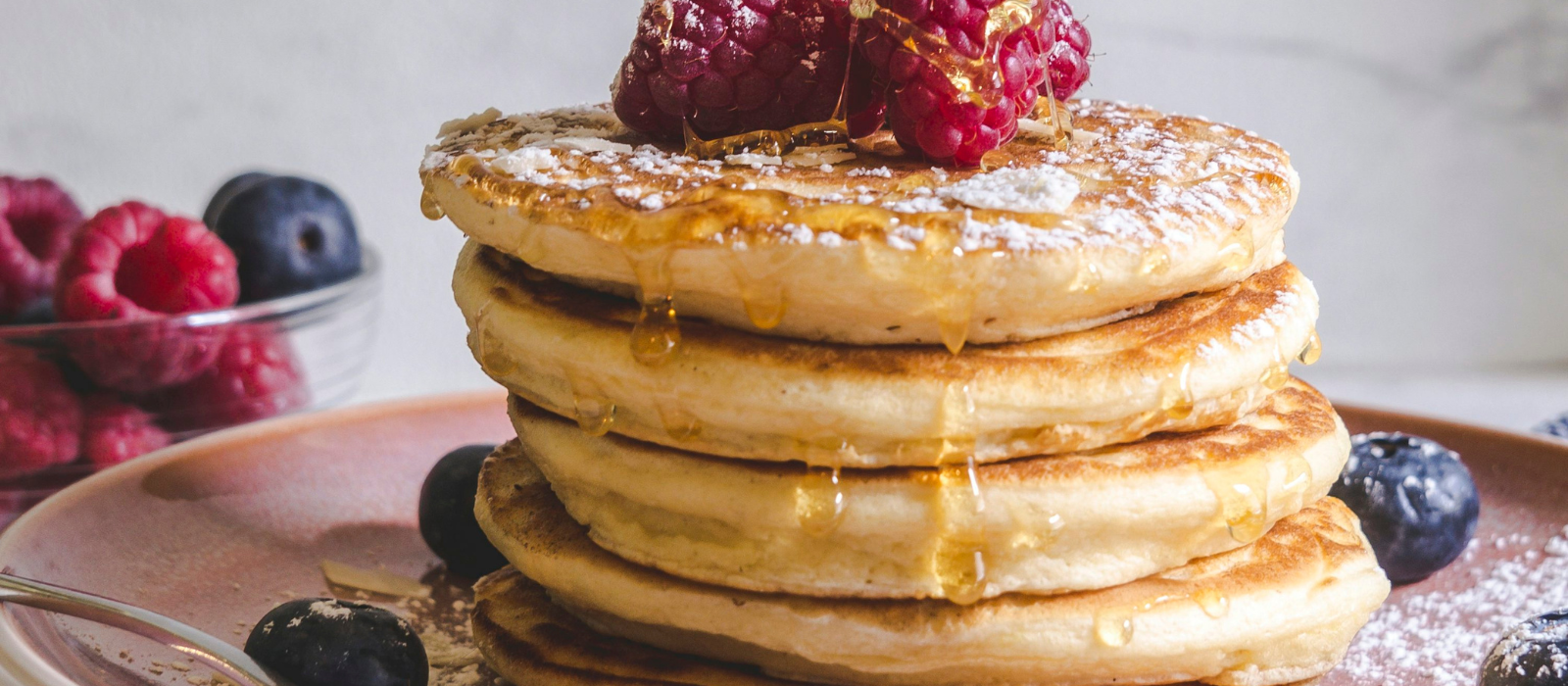 Classic Buttermilk Pancakes stacked and drizzled with maple syrup