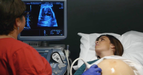Actresses modeling prenatal check-up scenarios using fake bellies