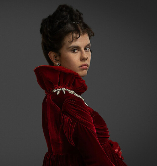 Mia Goth as Baroness Claire Frankenstein in red costume dress with bump