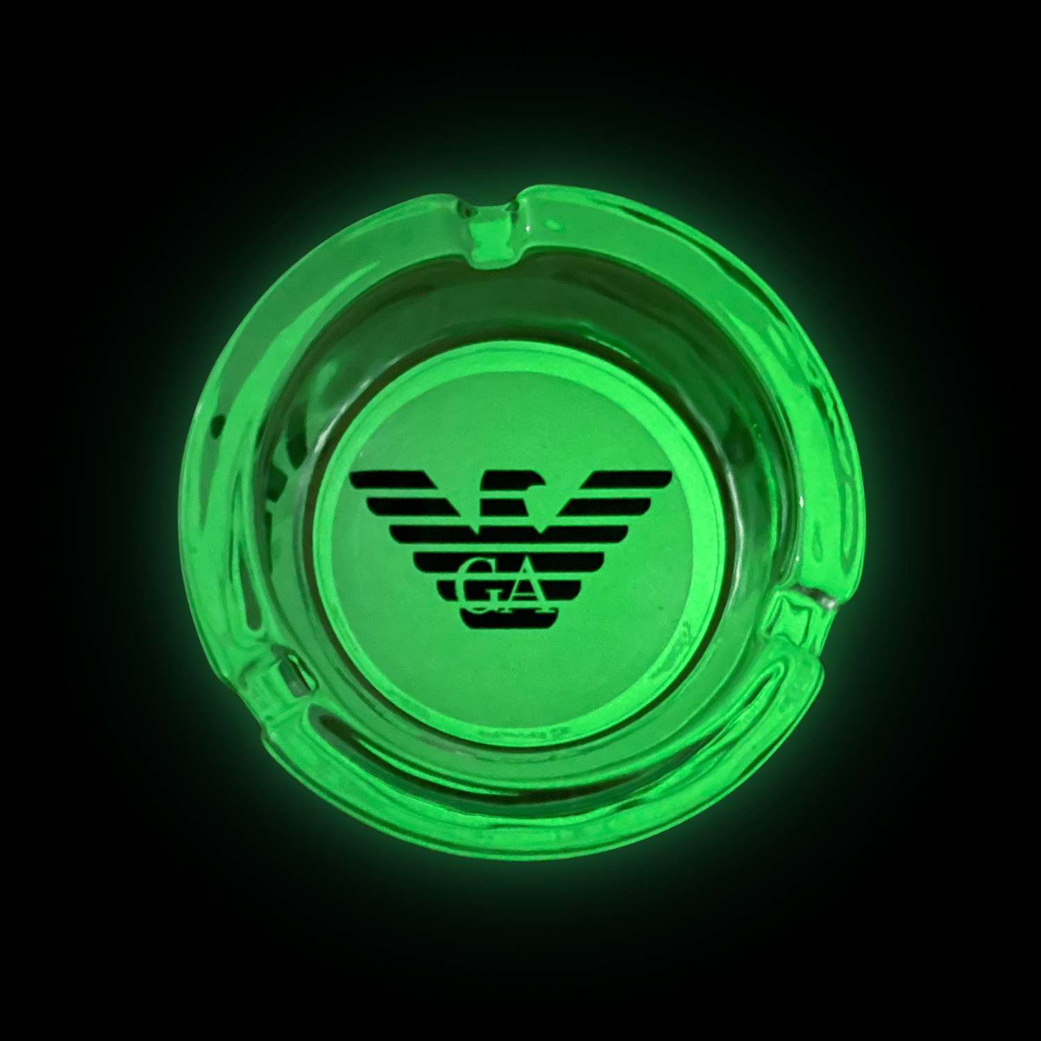 A LuminAsh glow in the dark custom glass ashtray with a logo