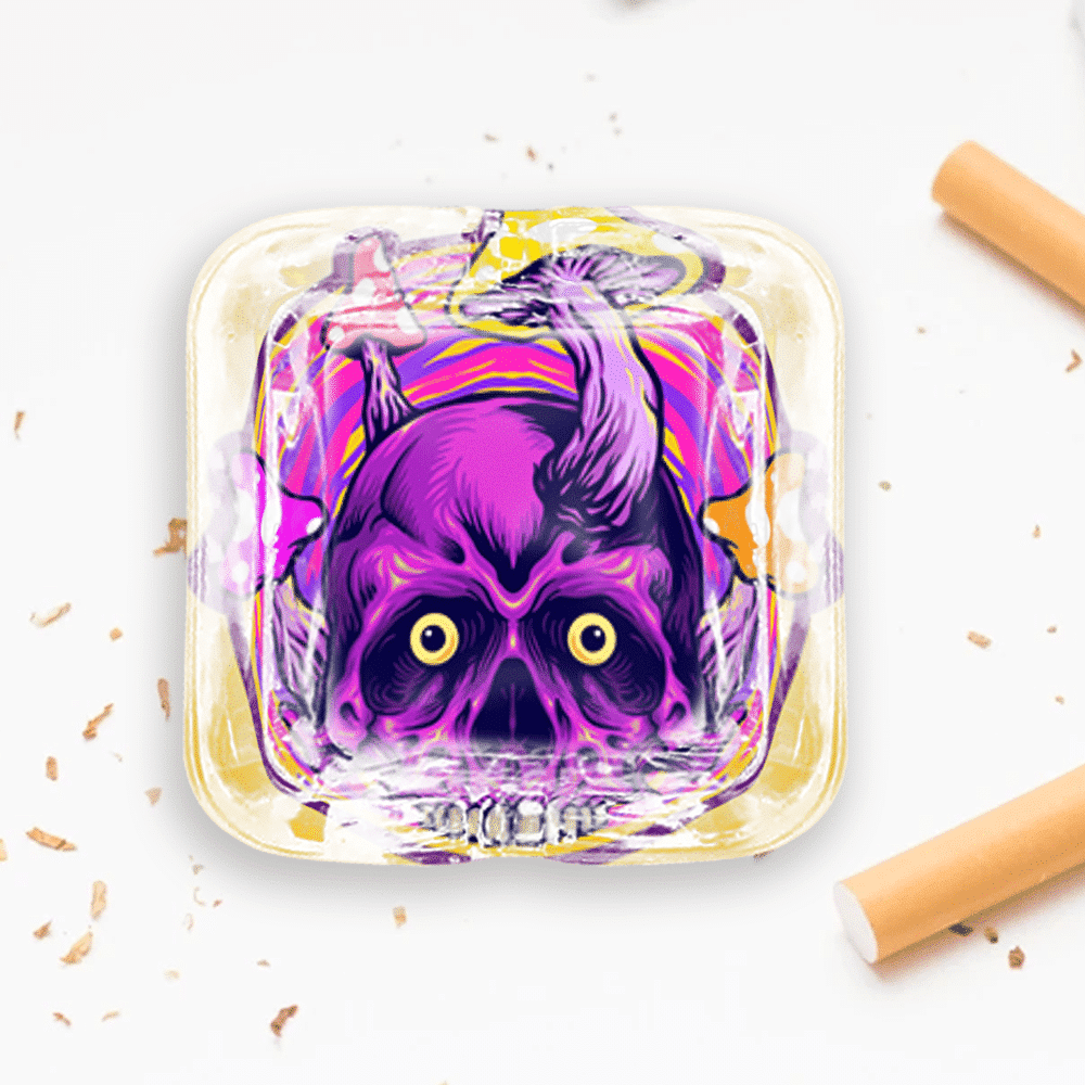 A custom square glass ashtray with a skull art design.