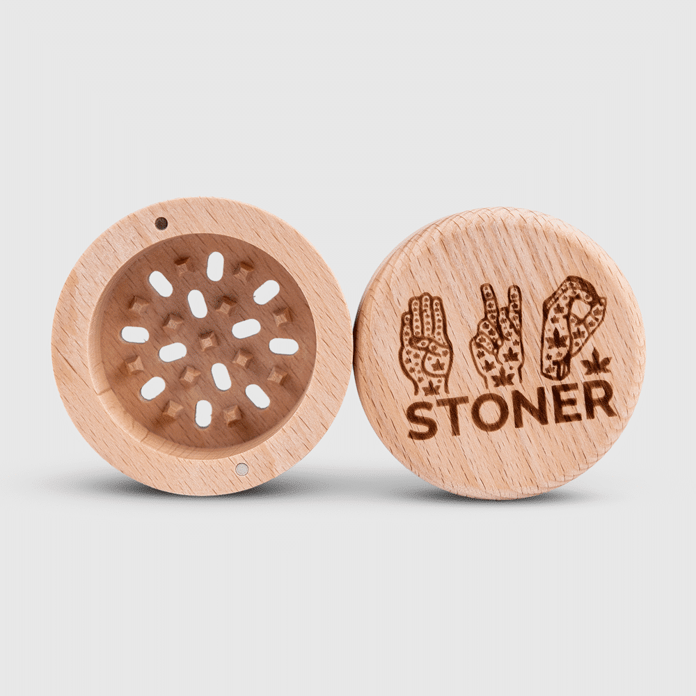 A person using the custom wooden grinder with a built-in glass jar.