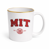 White MIT ceramic mug with red and black MIT lettering, Est. 1861 seal design and gold-tone rim.