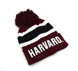 Shop the officially licensed Harvard maroon pom beanie featuring bold embroidered lettering and varsity stripe detail. A warm, classic knit winter hat for students and alumni.